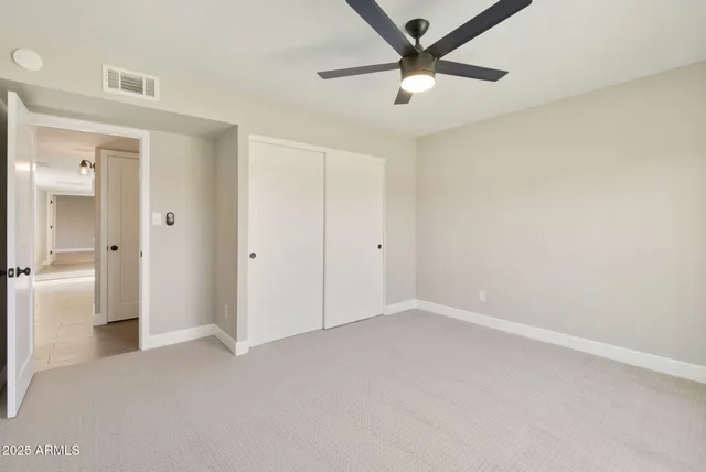 a view of an empty room and a ceiling fan