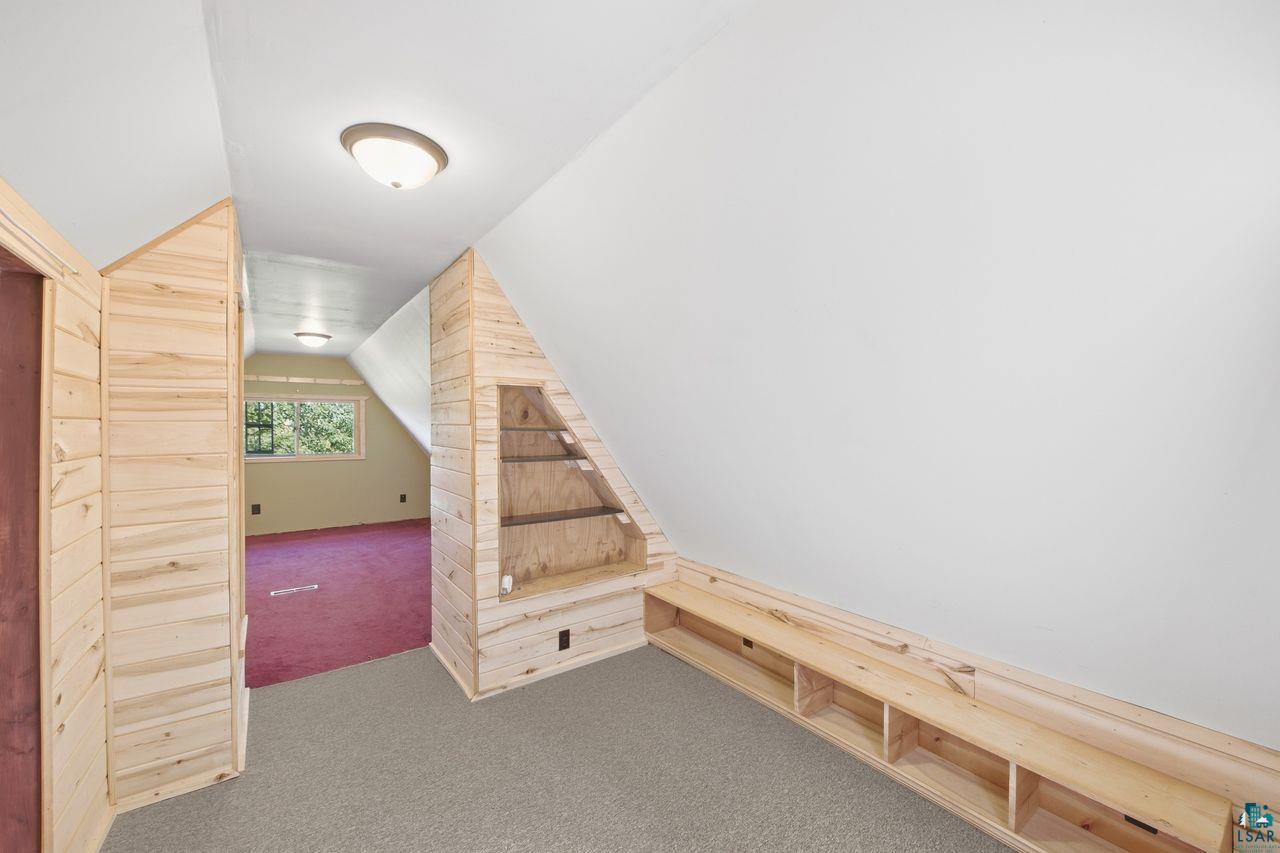 65889 Old County Road Marengo, WI 54855 - Photo 14 of 44 Sloped ceiling with recessed lighting, built-in shelving, wood-paneled walls, and soft carpet flooring