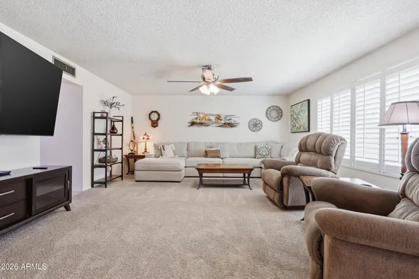 a living room with furniture a flat screen tv and a large window