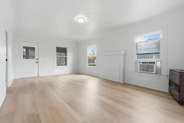 a view of an empty room with a window and fireplace