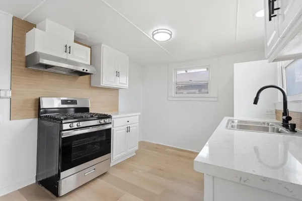 a kitchen with stainless steel appliances granite countertop a sink stove and cabinets