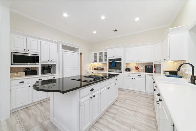a kitchen with counter top space a sink cabinets and stainless steel appliances