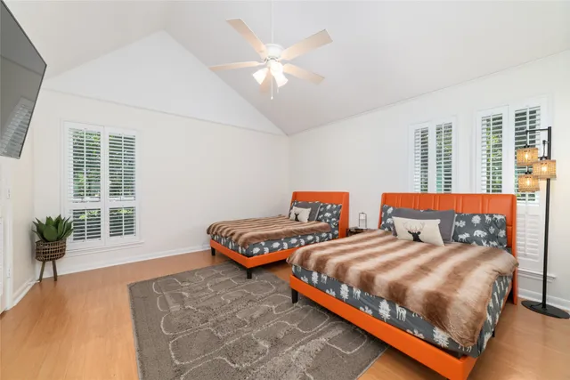 a bedroom with two beds and a potted plant