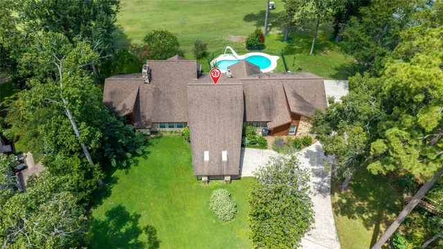 an aerial view of a house with a swimming pool and garden