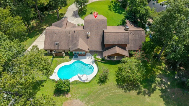 an aerial view of a house with a swimming pool and garden