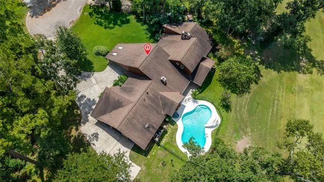 an aerial view of a house with a yard and trees