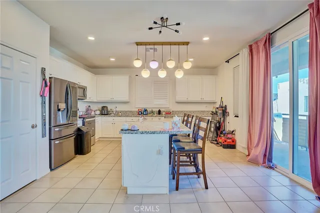 a kitchen with stainless steel appliances granite countertop a sink and a refrigerator