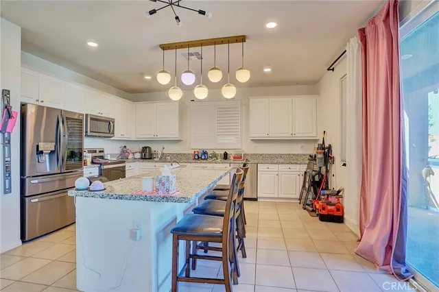 a kitchen with a dining table chairs sink and cabinets