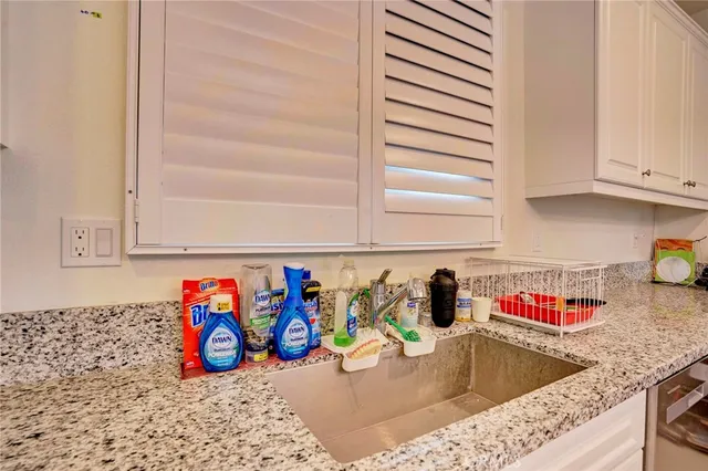 a kitchen with stainless steel appliances granite countertop a refrigerator stove and sink with wooden cabinets