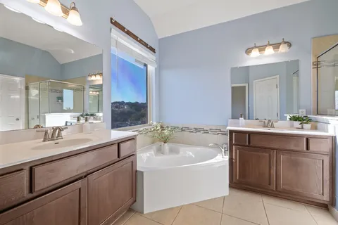 a bathroom with a tub sink and mirror