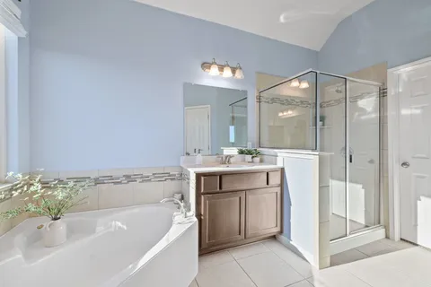 a bathroom with a bathtub sink and mirror