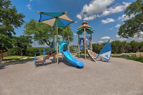 a view of a park with a large tree and a yard