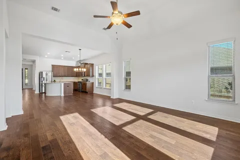 a open kitchen with white cabinets and wooden floor