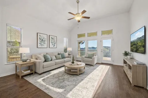 a living room with furniture a flat screen tv and a large window