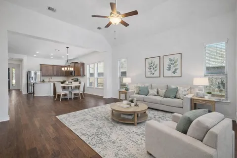 a living room with furniture and a dining table with kitchen view