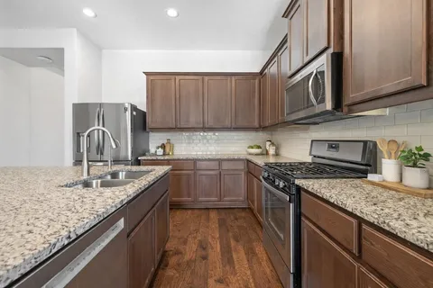 a kitchen with granite countertop stainless steel appliances and white cabinets