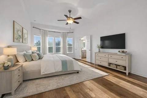 a spacious bedroom with a large bed and a flat screen tv