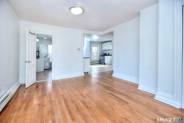 a view of empty room with wooden floor