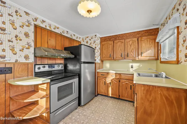 a kitchen with stainless steel appliances granite countertop a sink a stove and a refrigerator