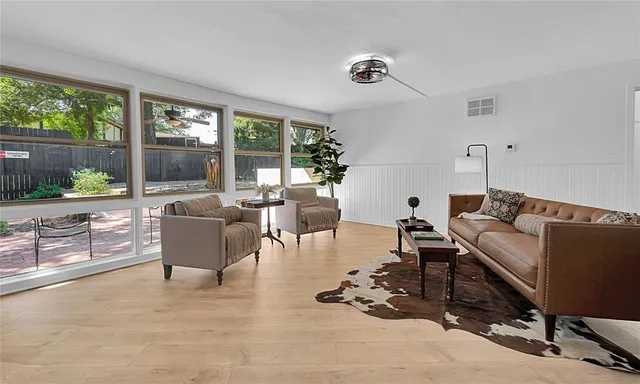 a living room with fireplace furniture and a large window