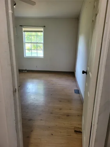 an empty room with wooden floor and a window