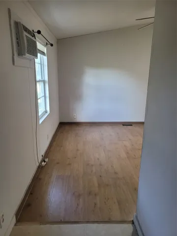 a view of a room with wooden floor and window