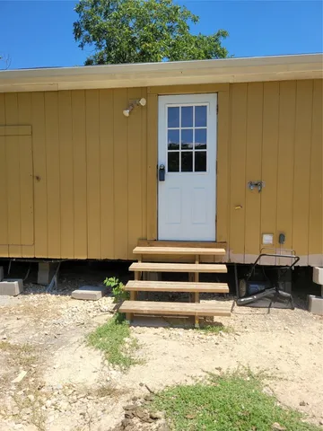 a view of a backyard with wooden fence and a tub