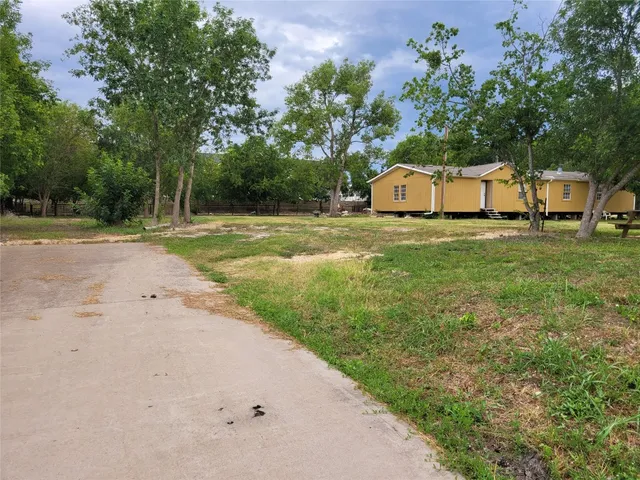 a front view of a house with a yard and trees