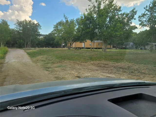 a view of swimming pool with a yard and large trees