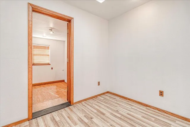 a view of empty room with wooden floor