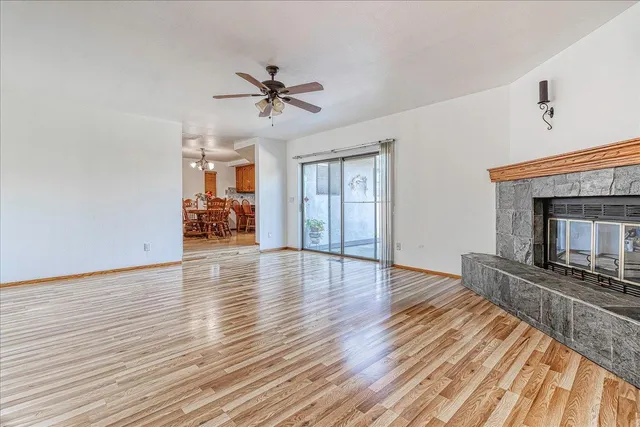 a view of a livingroom with wooden floor and a kitchen space