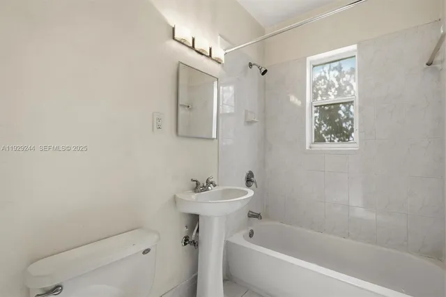 a bathroom with a sink mirror bathtub and toilet