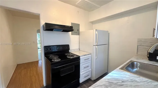 a kitchen with a refrigerator and a stove top oven