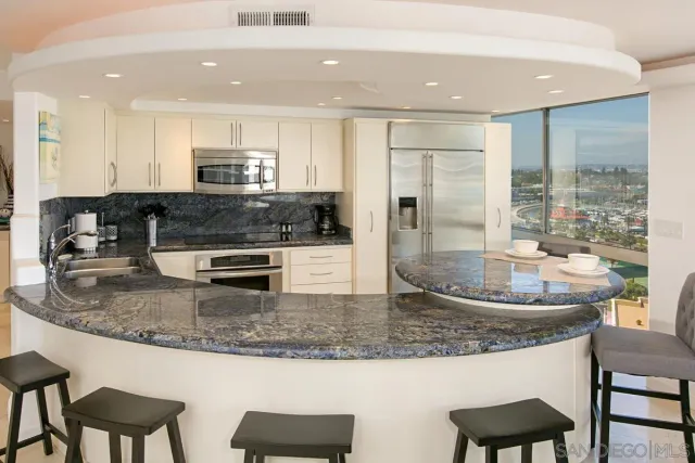 a kitchen with stainless steel appliances granite countertop a sink a stove a microwave a dining table and chairs