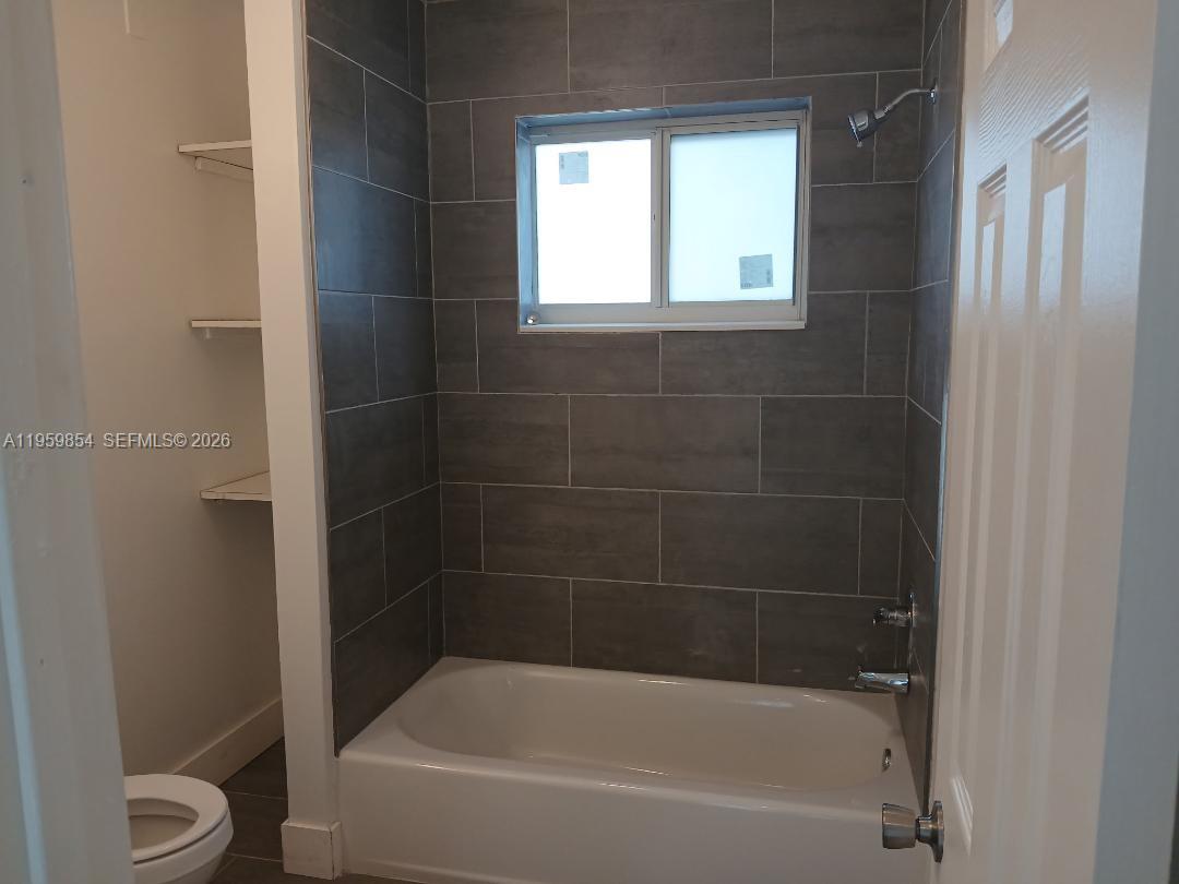 1535 Northwest 85th Street Miami, FL 33147 - Photo 5 of 7 a white bath tub sitting next to a toilet