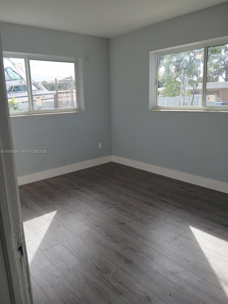 1535 Northwest 85th Street Miami, FL 33147 - Photo 6 of 7 an empty room with wooden floor and windows