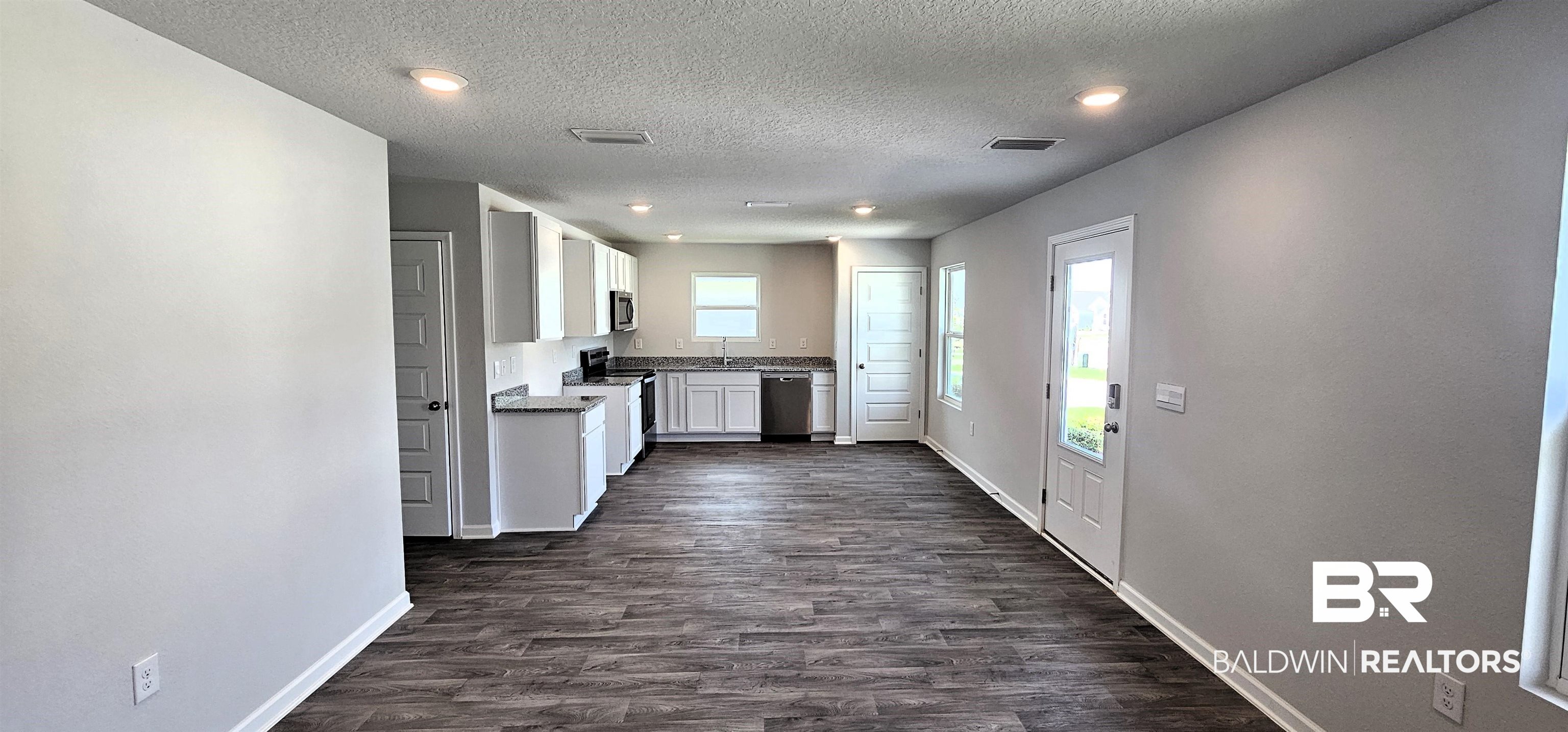 1144 Sweet Laurel Street Foley, AL 36535 - Photo 6 of 10 Kitchen with a textured ceiling, stainless steel appliances, white cabinetry, sink, and dark hardwood / wood-style floors