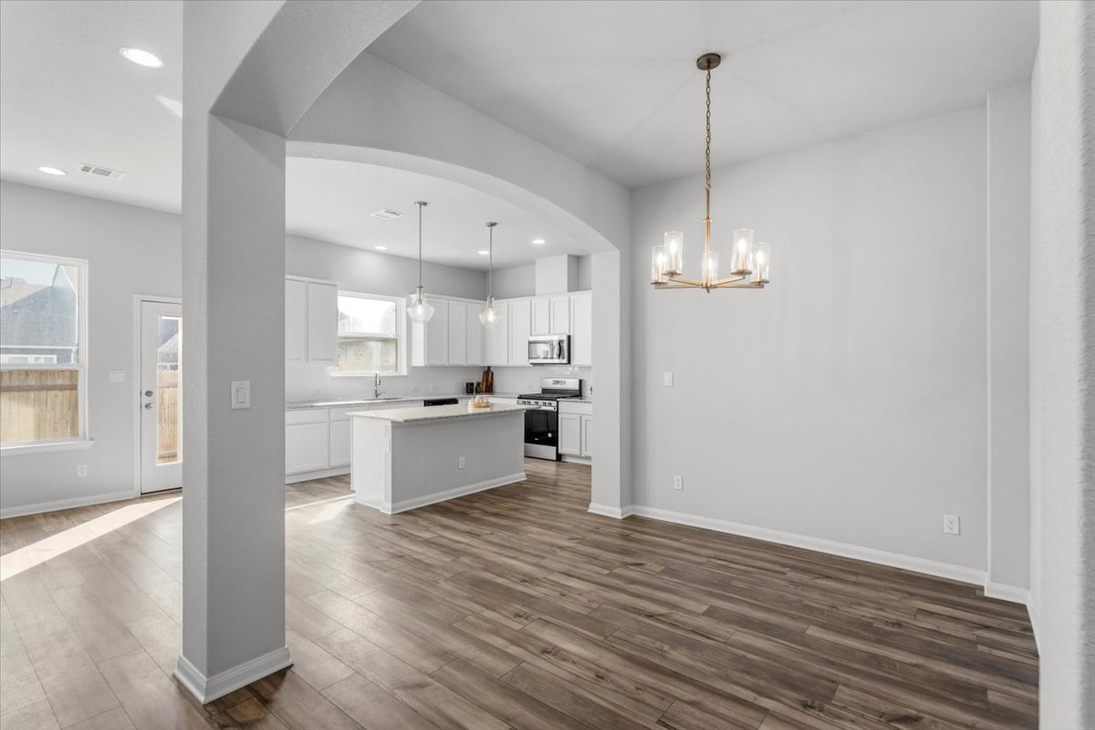 8513 Wellspring Loop Round Rock, TX 78665 - Photo 40 of 40 Kitchen with white cabinetry, a center island, stainless steel appliances, open floor plan, and dark wood-type flooring