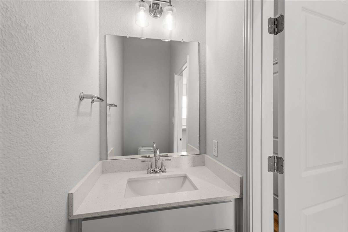 8513 Wellspring Loop Round Rock, TX 78665 - Photo 15 of 40 Half bathroom featuring a textured wall and vanity