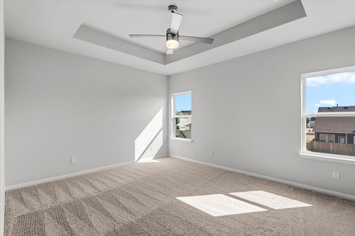 8513 Wellspring Loop Round Rock, TX 78665 - Photo 22 of 40 Empty room with a raised ceiling, ceiling fan, and carpet flooring
