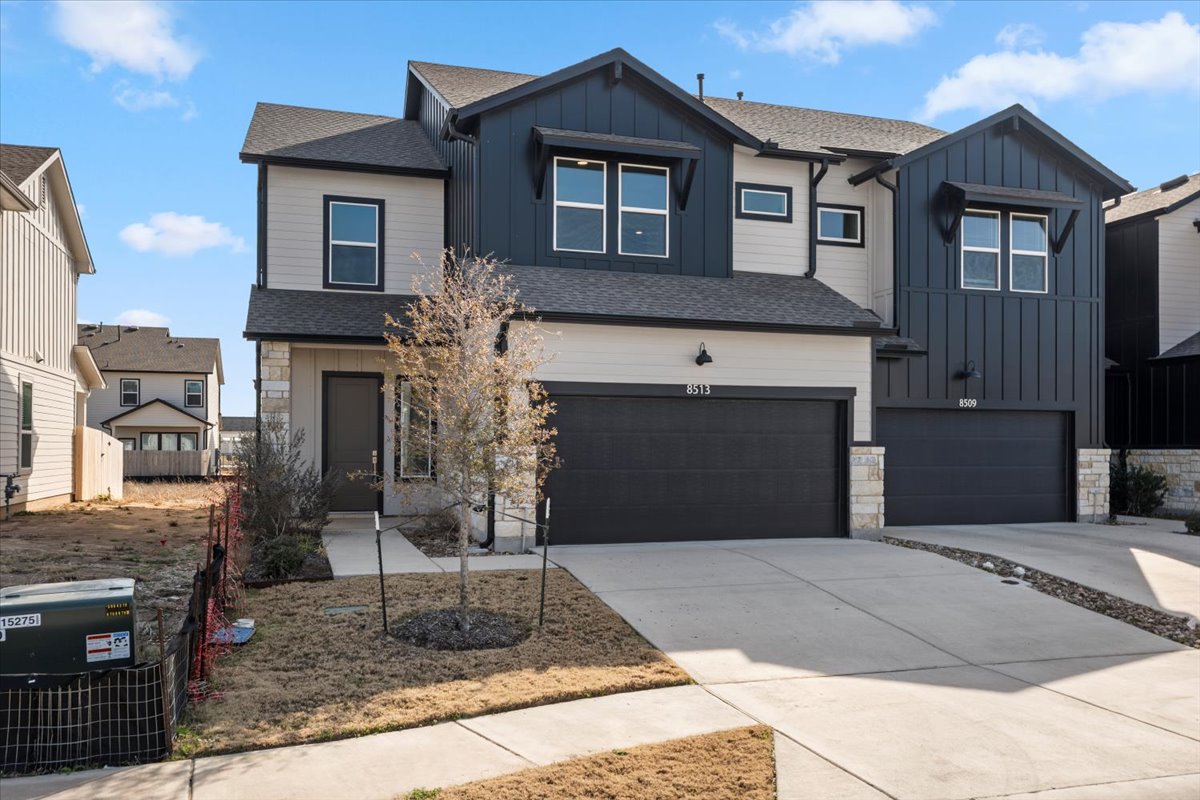 8513 Wellspring Loop Round Rock, TX 78665 - Photo 3 of 40 View of front facade with board and batten siding, stone siding, a shingled roof, and driveway