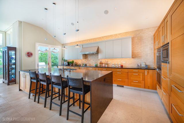 a kitchen with stainless steel appliances granite countertop table chairs sink and cabinets