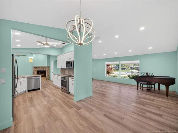 a view of a dining room with furniture a chandelier and wooden floor