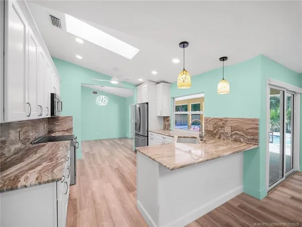 a kitchen with kitchen island a sink stove and view living room