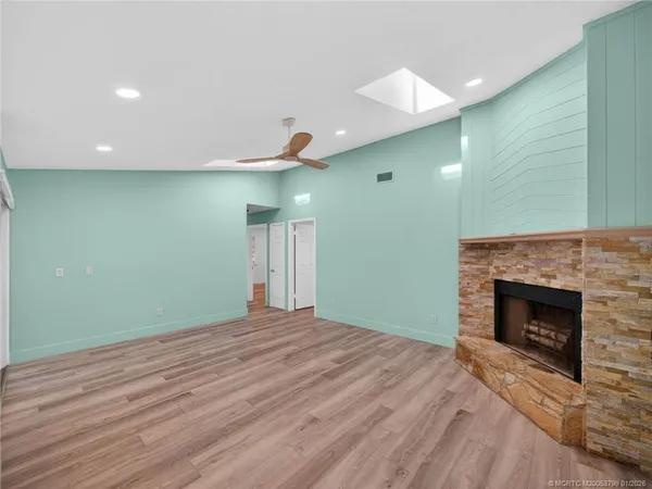 a view of empty room with wooden floor and fireplace