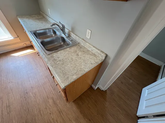 a kitchen with sink dryer and wooden floor