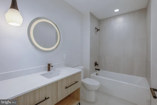 a bathroom with a sink toilet a mirror and bathtub