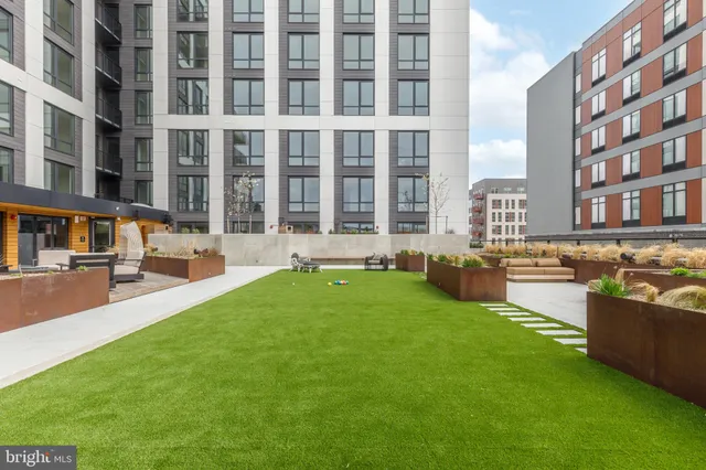 a swimming pool with outdoor seating and a garden