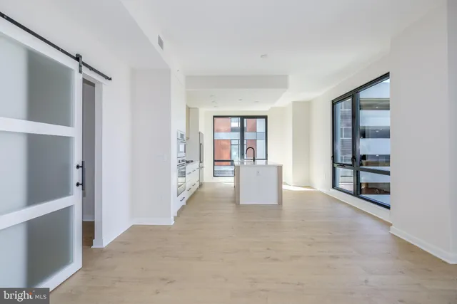 a view of a hallway with painting on the wall and a window