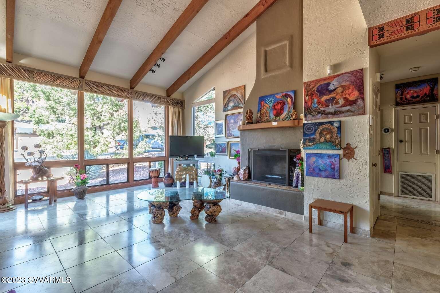 25 Homestead Road Sedona, AZ 86336 - Photo 11 of 25 a living room with furniture a fireplace and a floor to ceiling window
